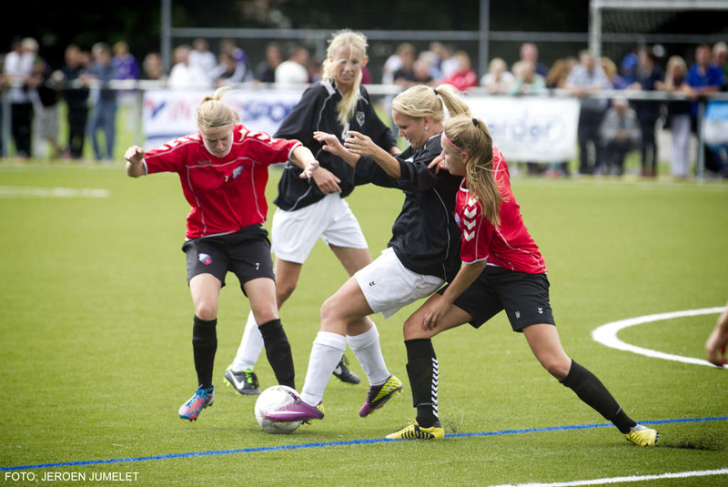 Daisy de Smalen (midden, in zwart shirt) in actie tegen FC Utrecht; Karin Snoek kijkt op de achtergrond toe.